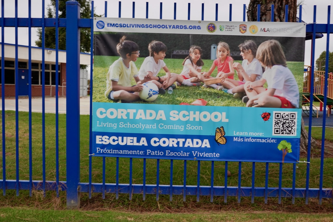 Cortada Elementary before renovation: bare asphalt schoolyard with no shade or greenery.