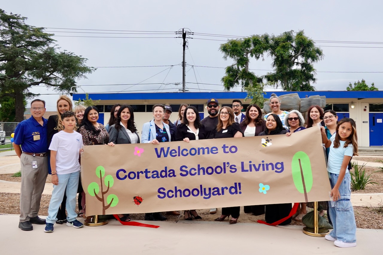 Community members and school staff celebrate at the Cortada Living Schoolyard ribbon cutting ceremony.