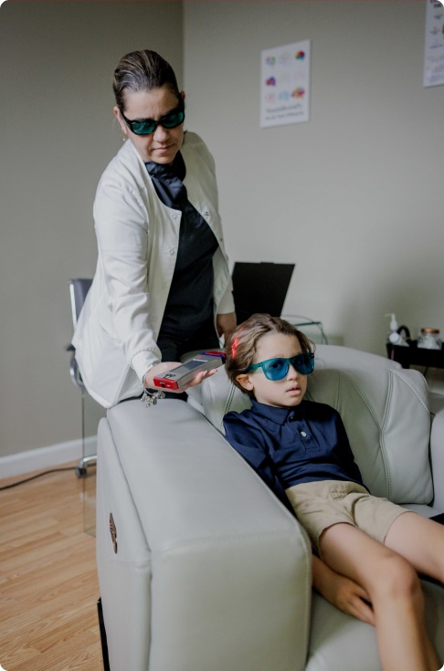 Experta de Developing Brains aplicando servicio de Fotobiomodulación a un niño con autismo