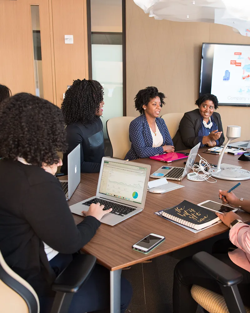 Group of women in a meeting looking at data and discussing