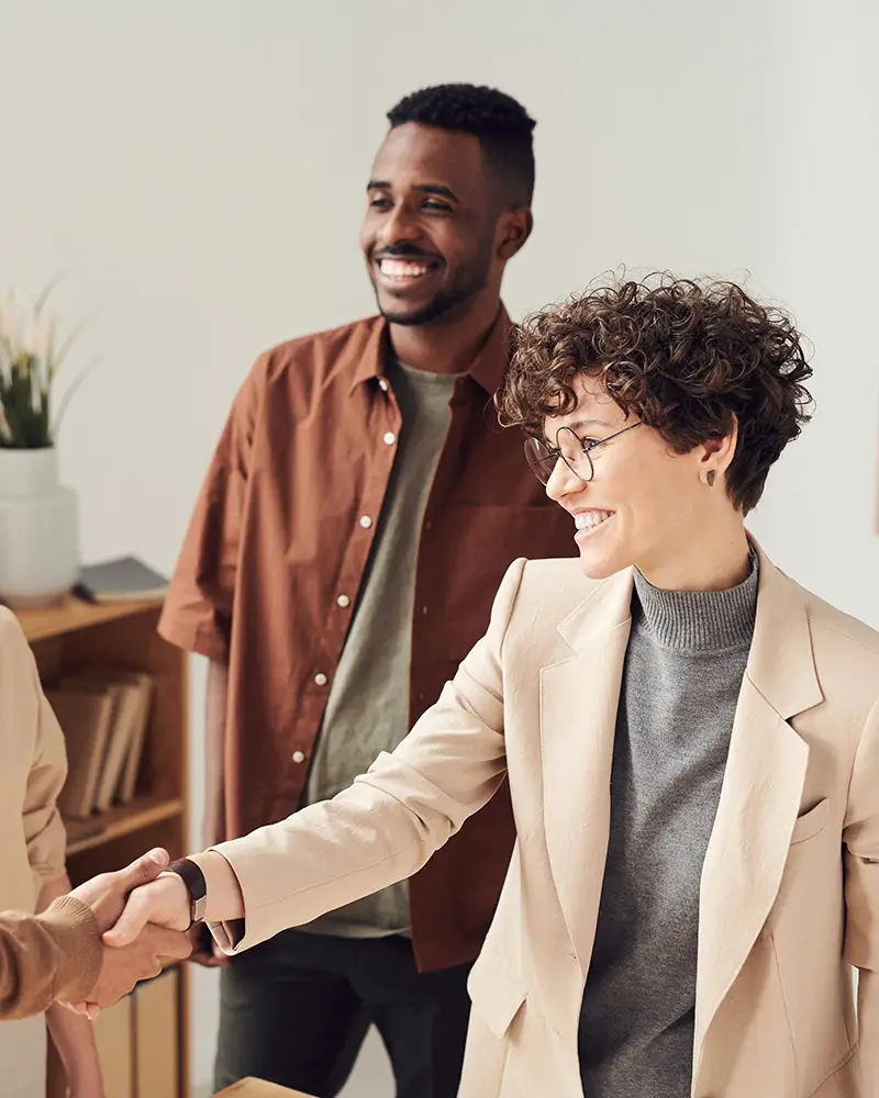 Two people shaking hands in an informal meeting.