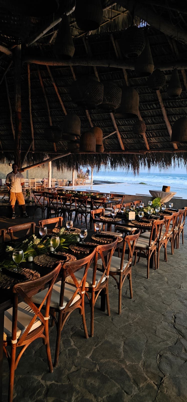 Long wedding reception tables beside the ocean