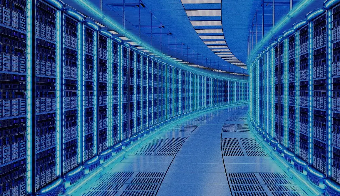 Futuristic hallway of a data center with glowing blue-lit server racks stretching along curved walls.
