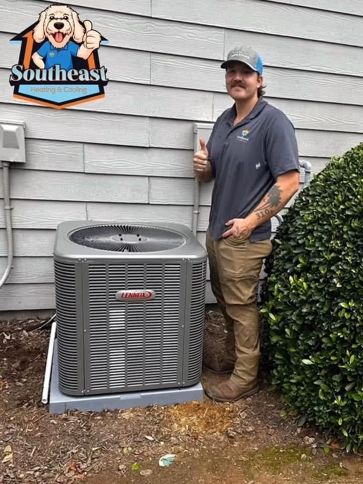 HVAC technician stands next to Lennox air conditioning unit giving thumbs up.