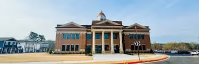Historic county courthouse with columns and dome under clear blue sky.
