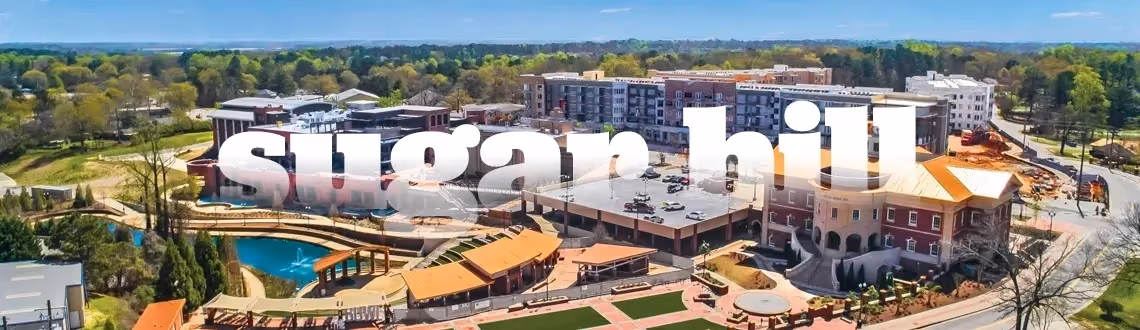 Aerial view of Sugar Hill downtown with large white letters and modern buildings.