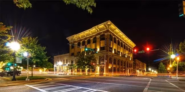 Historic downtown building illuminated at night with street lights and traffic signals.