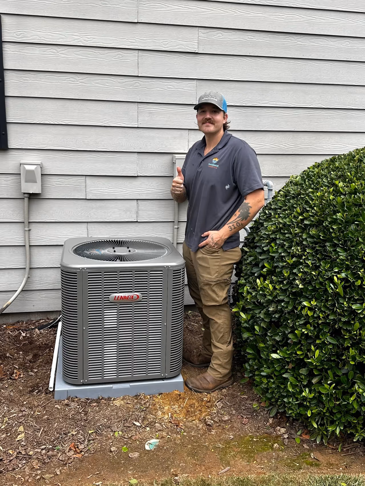 HVAC technician giving thumbs up next to Lennox air conditioning unit.