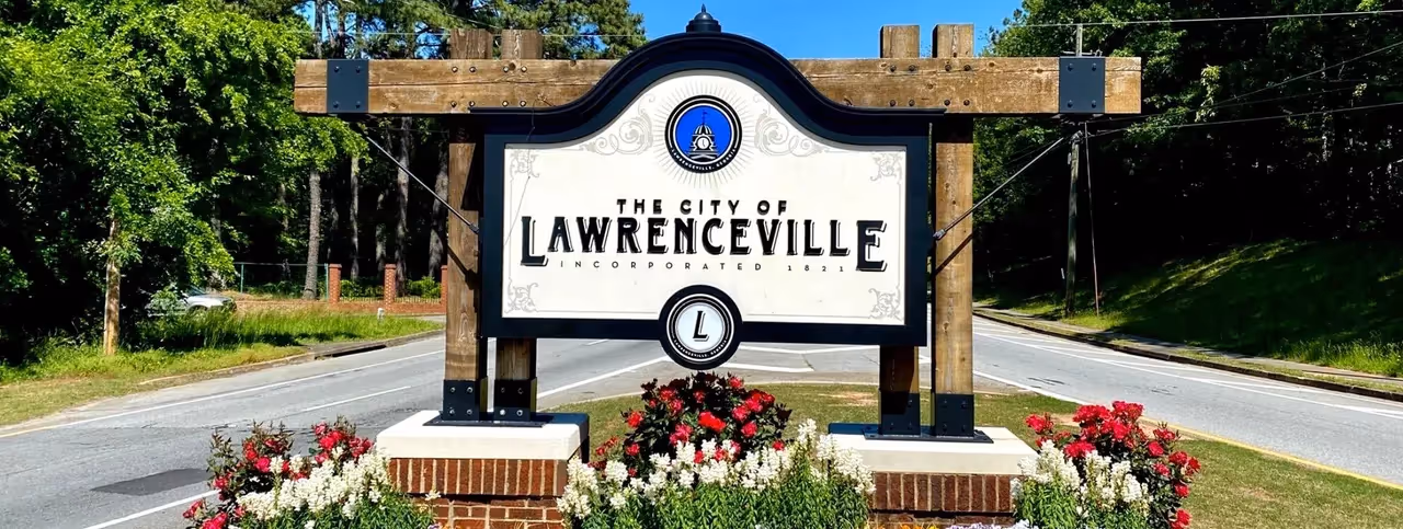 Lawrenceville city welcome sign with red and white flowers
