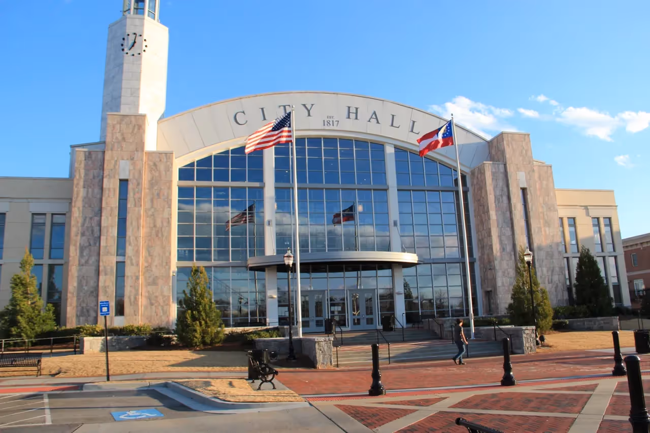 Modern city hall building with clock tower and American and state flags