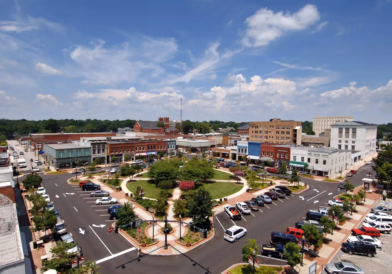 Aerial view of small town downtown with central circular park and surrounding streets