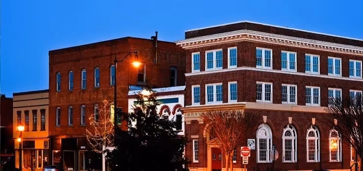 Historic brick buildings at twilight with street lamps and arched windows