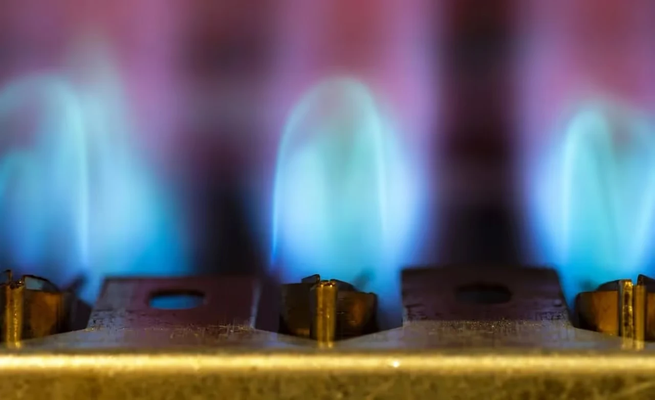 Blue and purple flames burning on gas stove burners close-up