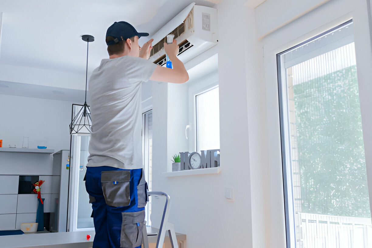 Technician installing or repairing an air conditioning unit indoors