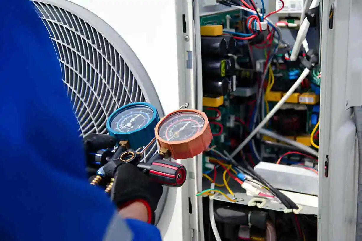 Technician checking pressure gauges inside an electrical or HVAC system panel