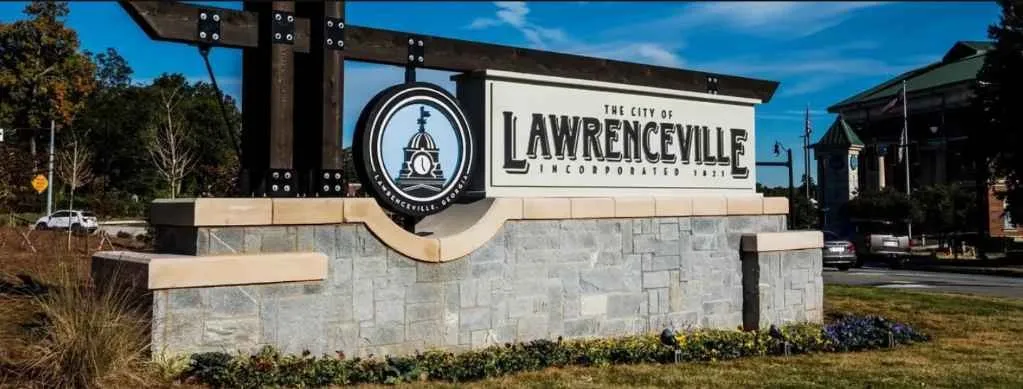 Lawrenceville city sign with municipal logo on stone monument