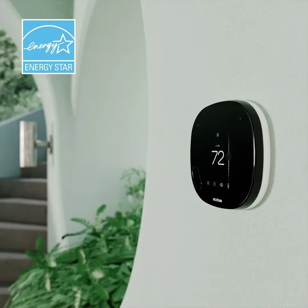Energy Star certified smart thermostat mounted on light wall near stairs
