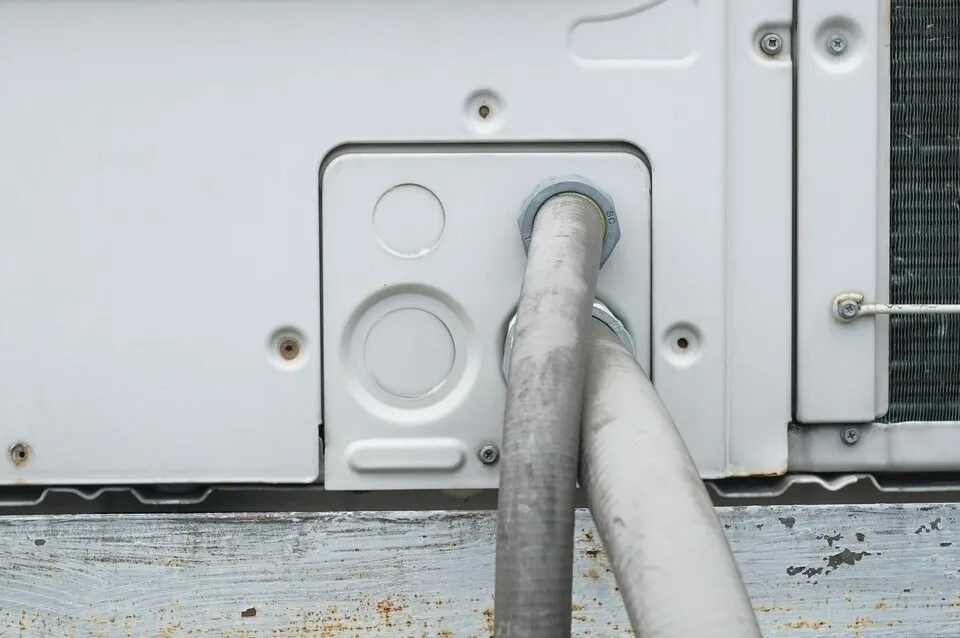  Close-up of pipes connected to an outdoor AC unit.