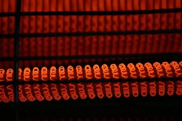 Glowing orange caterpillar-like segments forming repeating geometric pattern