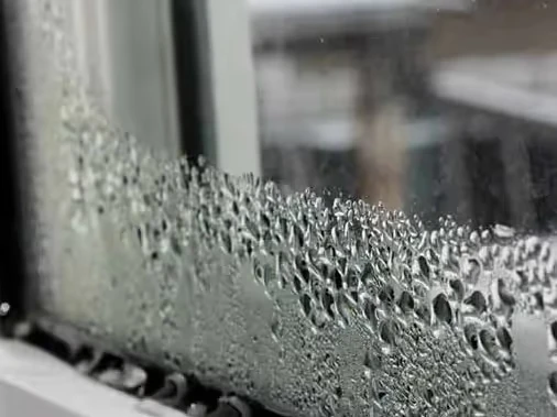 Condensation droplets on window glass with blurry background