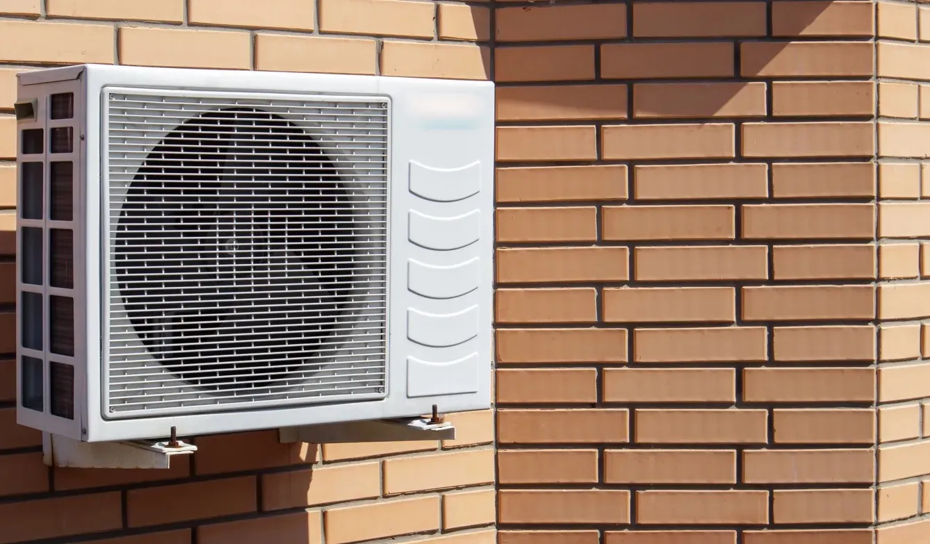 Modern white air conditioning unit mounted between wooden panels