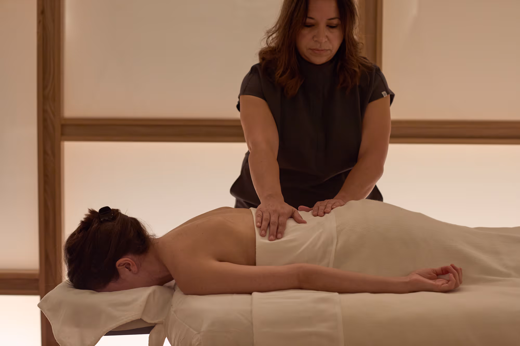 Tributary massage therapist providing a body massage