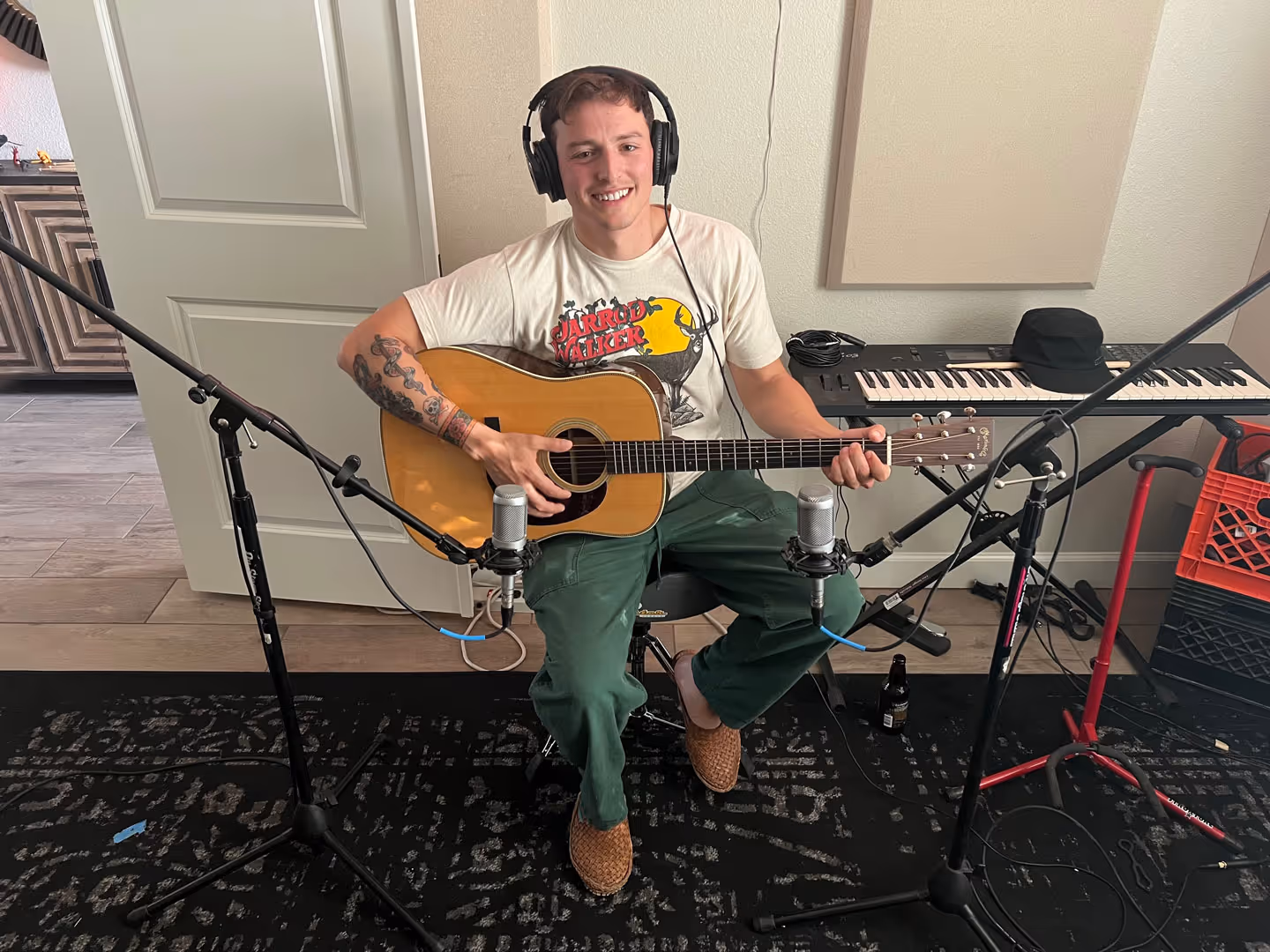 A guitarist recording an acoustic guitar at Phil Hodges Productions studio.