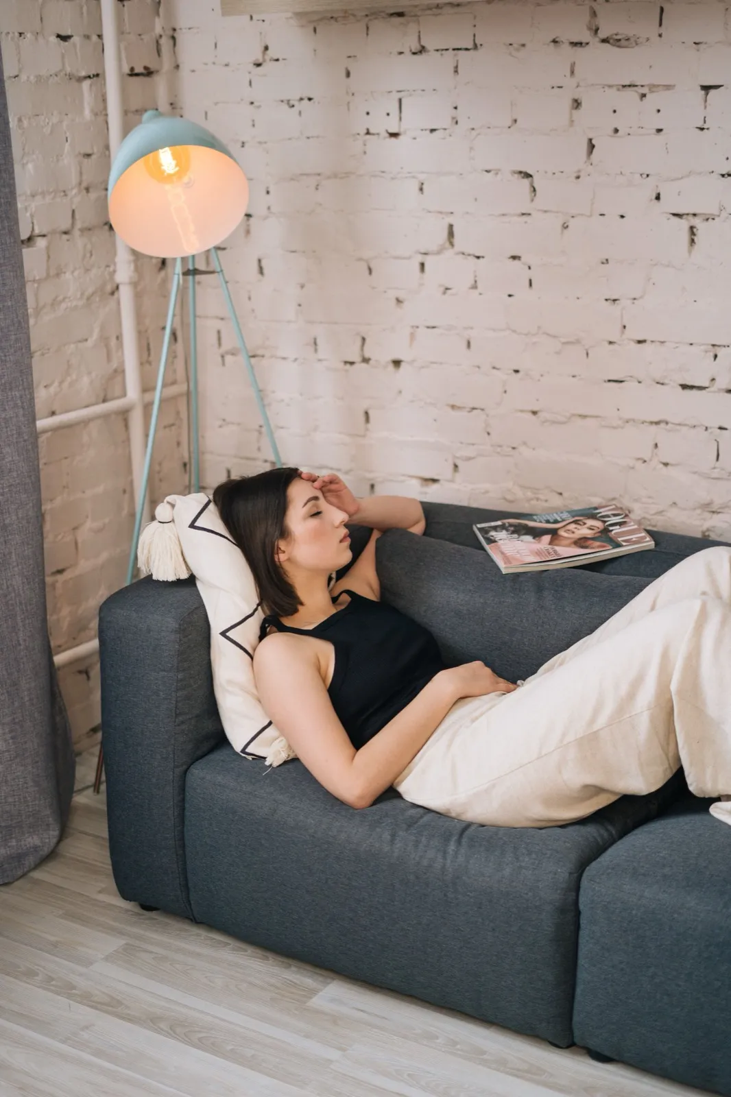 A tired woman resting on a sofa after the energy cost of ADHD masking