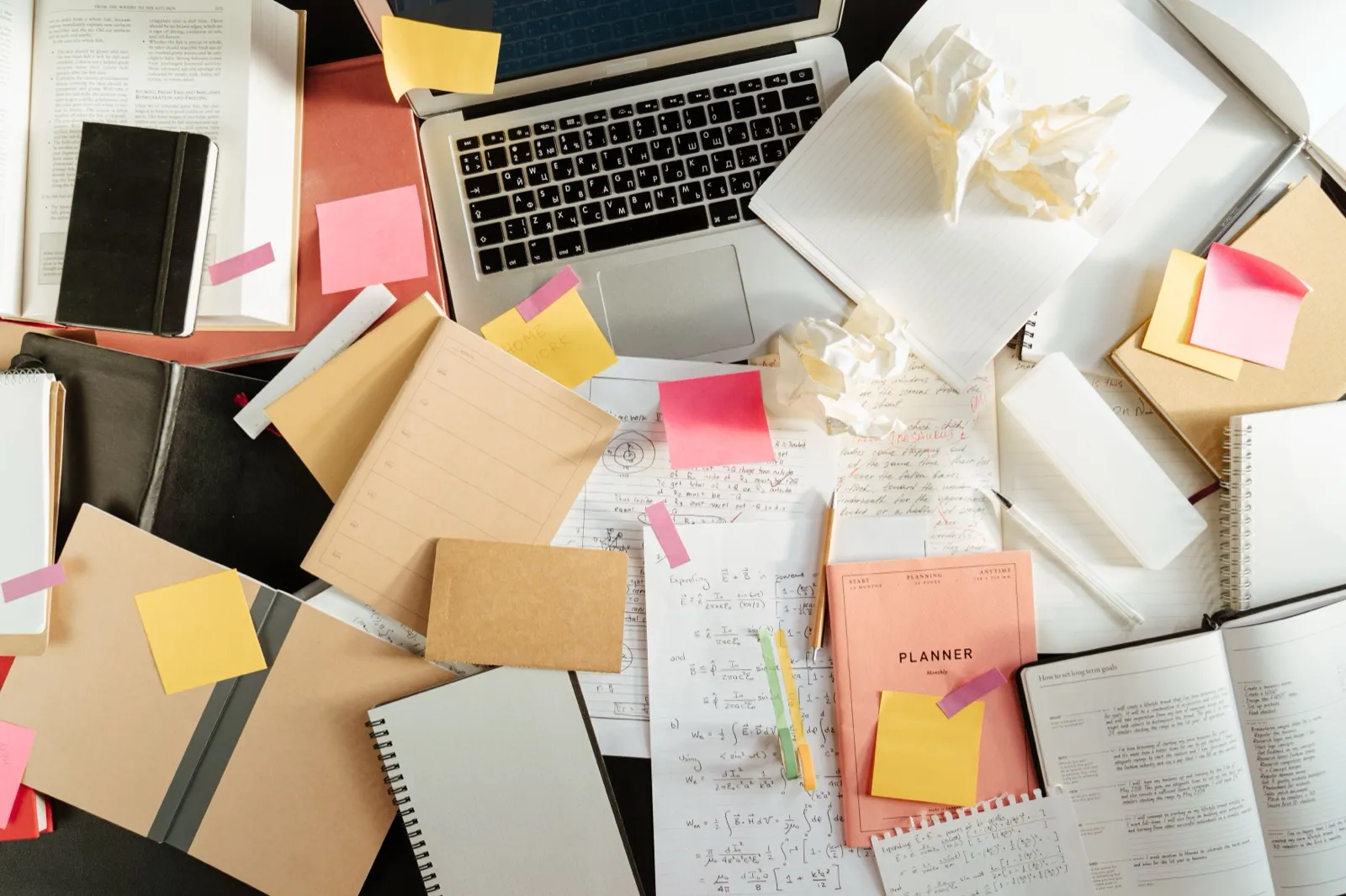 Scattered notes and sticky notes representing the many open tabs in an ADHD mind