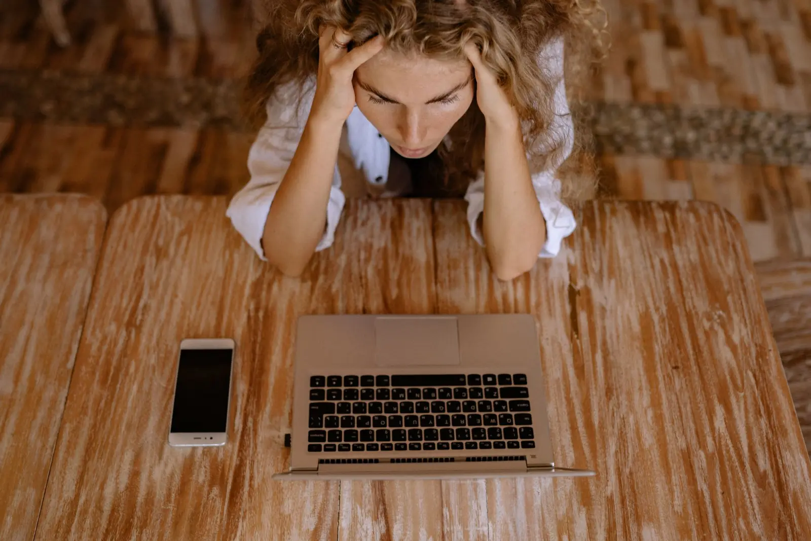 A stressed woman at a laptop, illustrating the difficulty of initiating tasks with ADHD