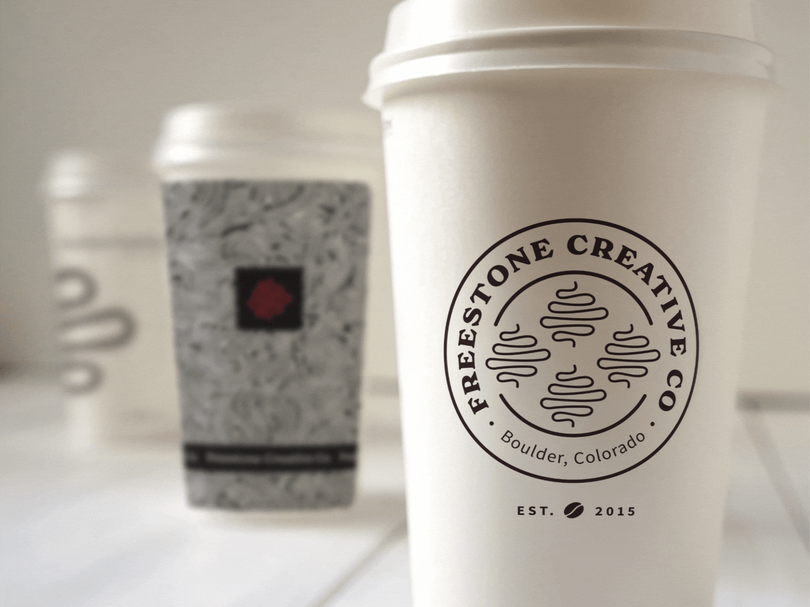 Freestone Creative Co. branded coffee cups alternating in a GIF with different branded graphics.