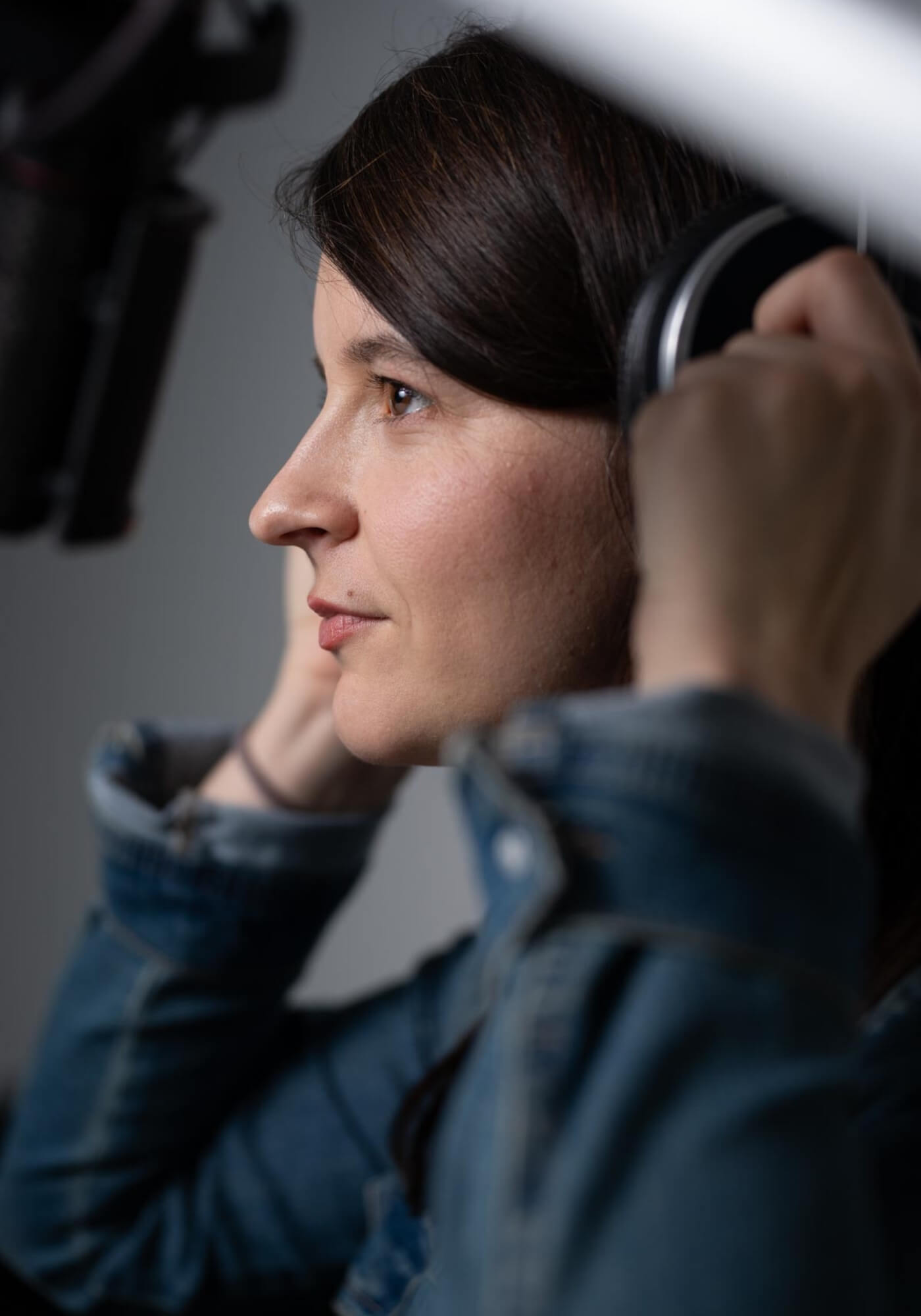 Marlene Groihofer von audioportait am Mikrofon für Audioaufnahmen. Sie richtet sich ihre Kopfhörer zurecht.