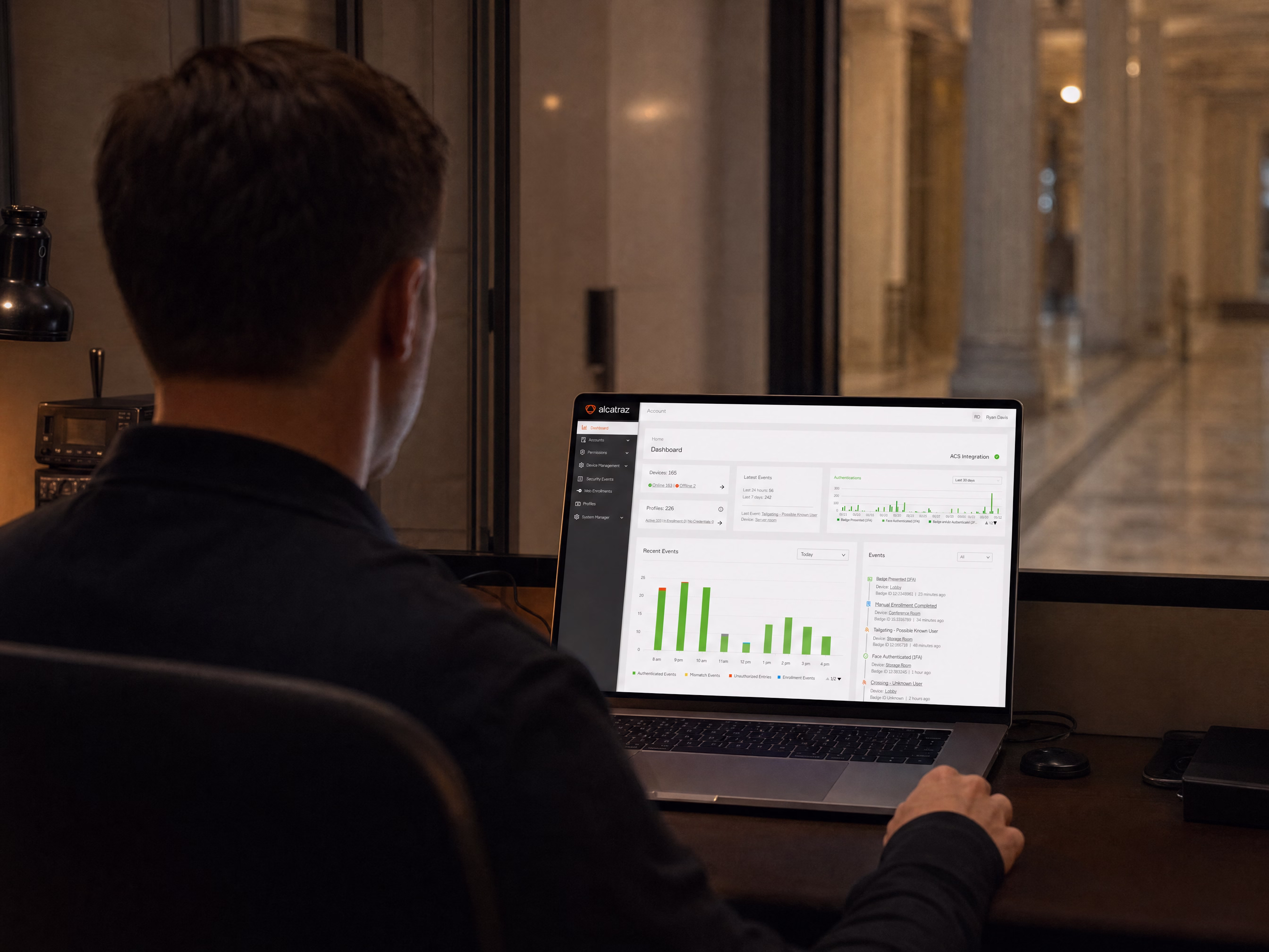 A security administrator reviewing the Rock Cortex dashboard at a workstation inside a government building