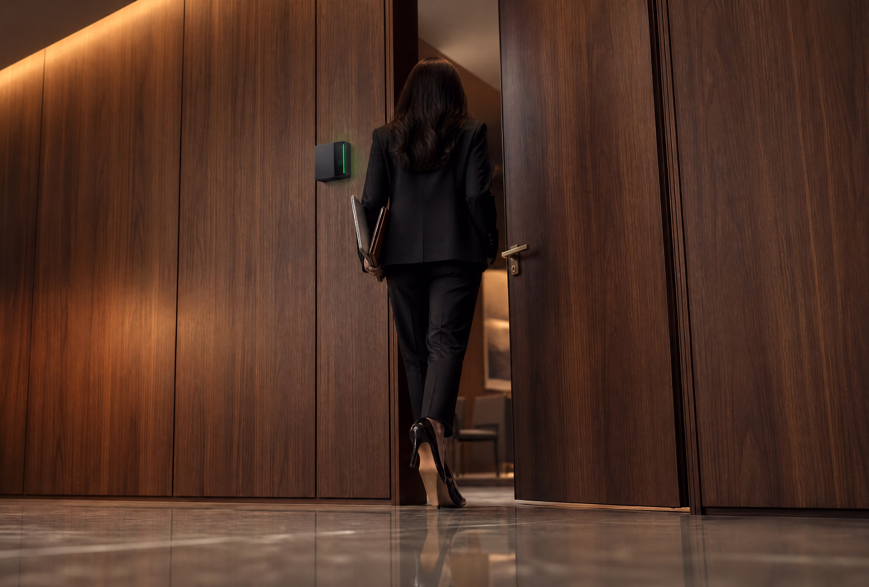 A tenant in a dark suit passing through a wood-panelled office door beside a wall-mounted Rock reader