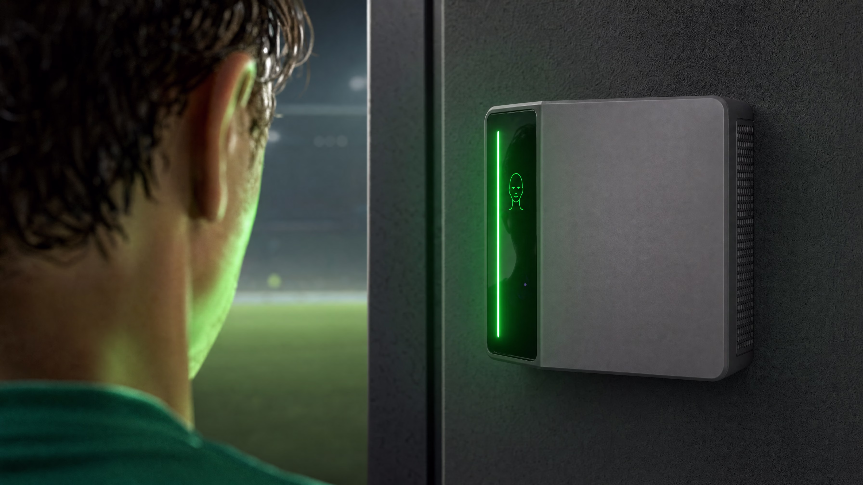 A player at a Rock X reader whose green light bar confirms the verified face, the floodlit pitch beyond