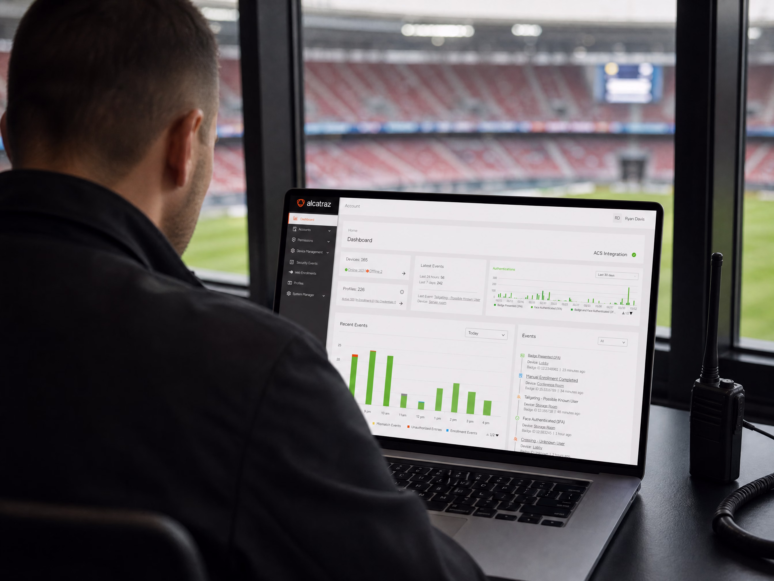 A security operator reviewing the Rock Cortex dashboard from a suite overlooking the pitch