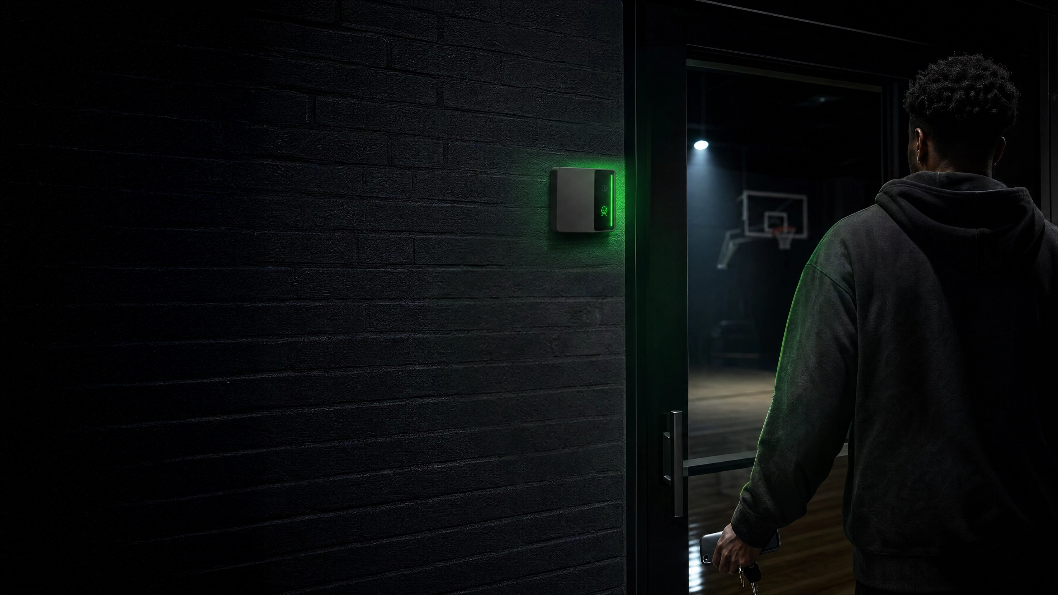 An athlete arriving at a dark brick side entrance to a court as the Rock reader beside the door glows green