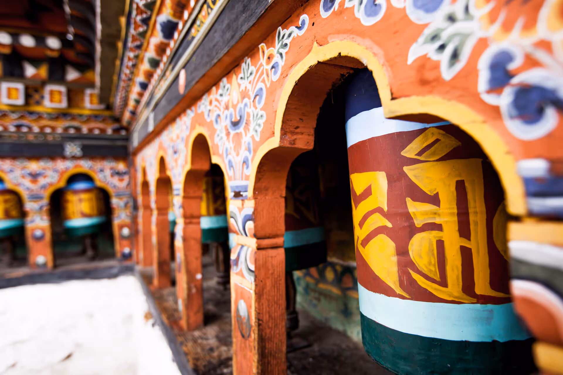 Contact form with traditional Bhutanese prayer wheels in the background, inviting guests to plan their perfect trip to Bhutan.