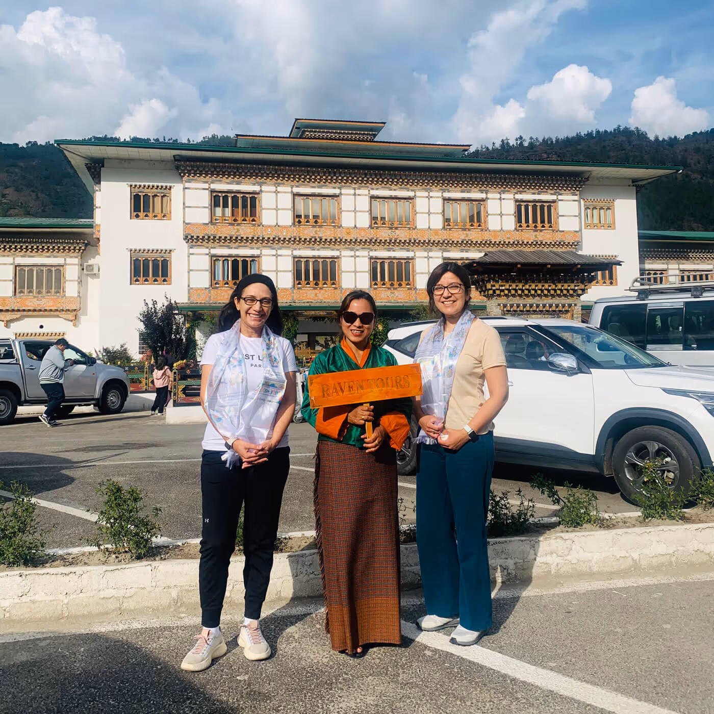 Warm Raven Tours welcome at Paro Airport, with a smiling local host holding a handcrafted sign to greet arriving guests.