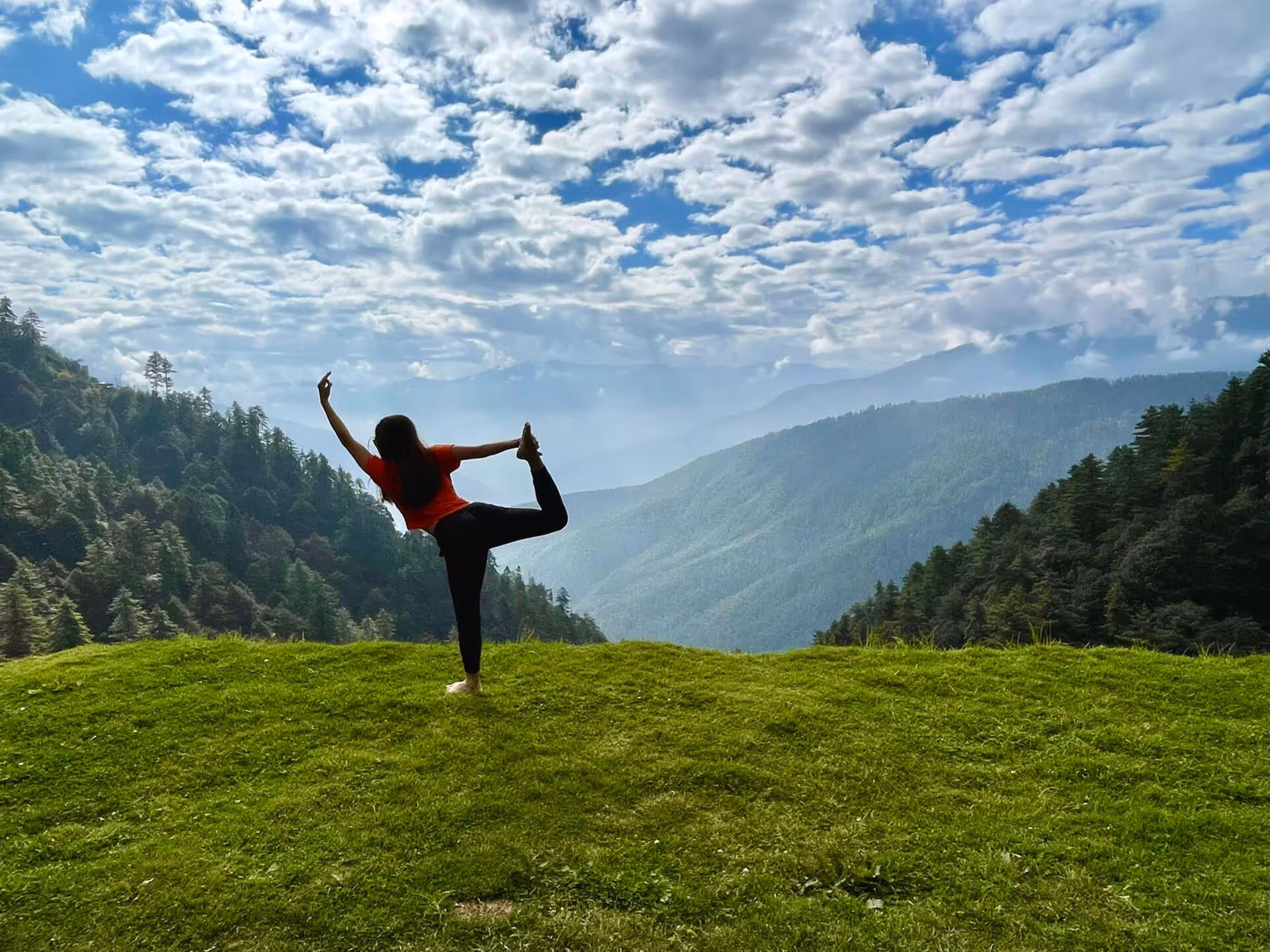 Traveler practicing yoga during Longtey Hike in Gangtey, Bhutan, with lush forest and mountain views.

