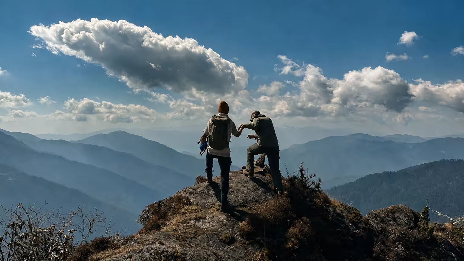 A Raven guide helping a traveller on a mountain viewpoint in Bhutan