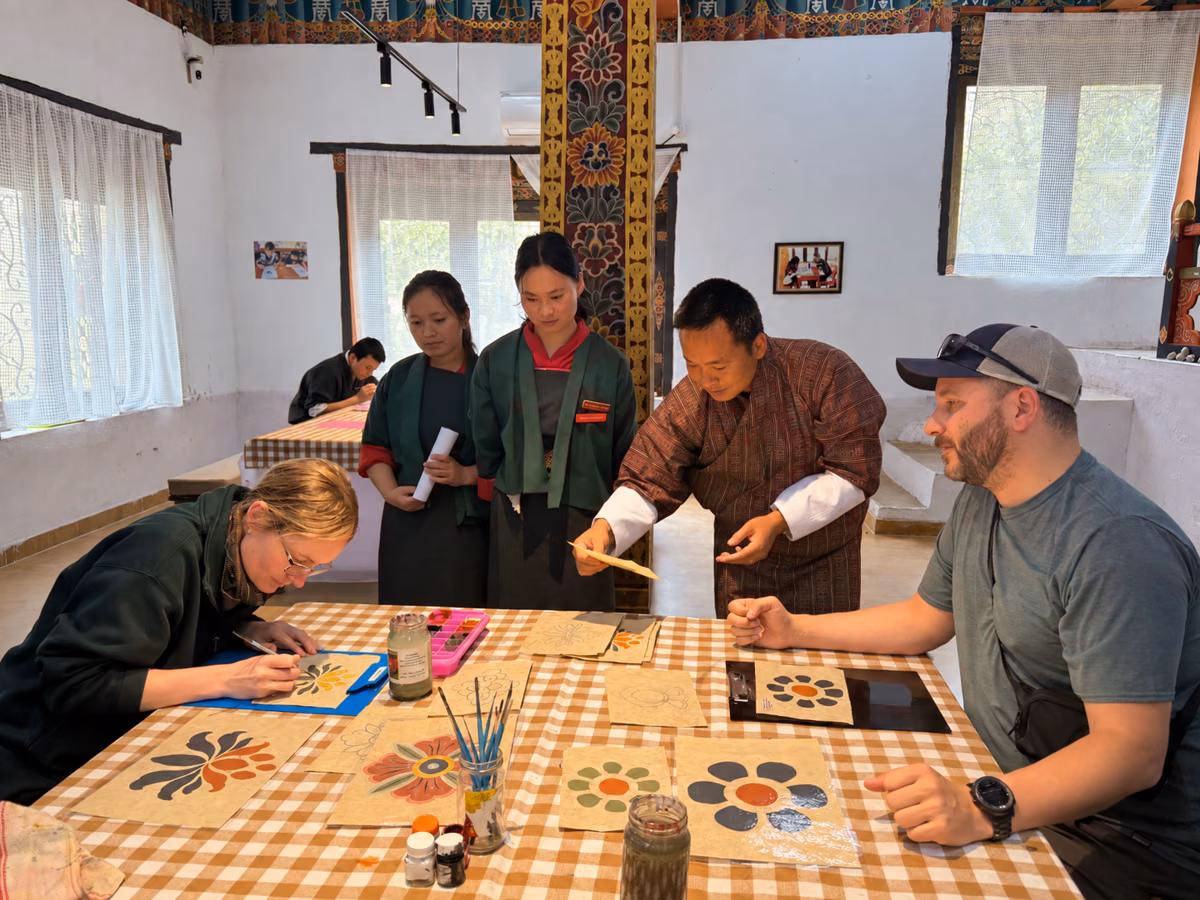 Guests painting traditional floral motifs with local instructors during a craft workshop at Choki, Thimphu.
