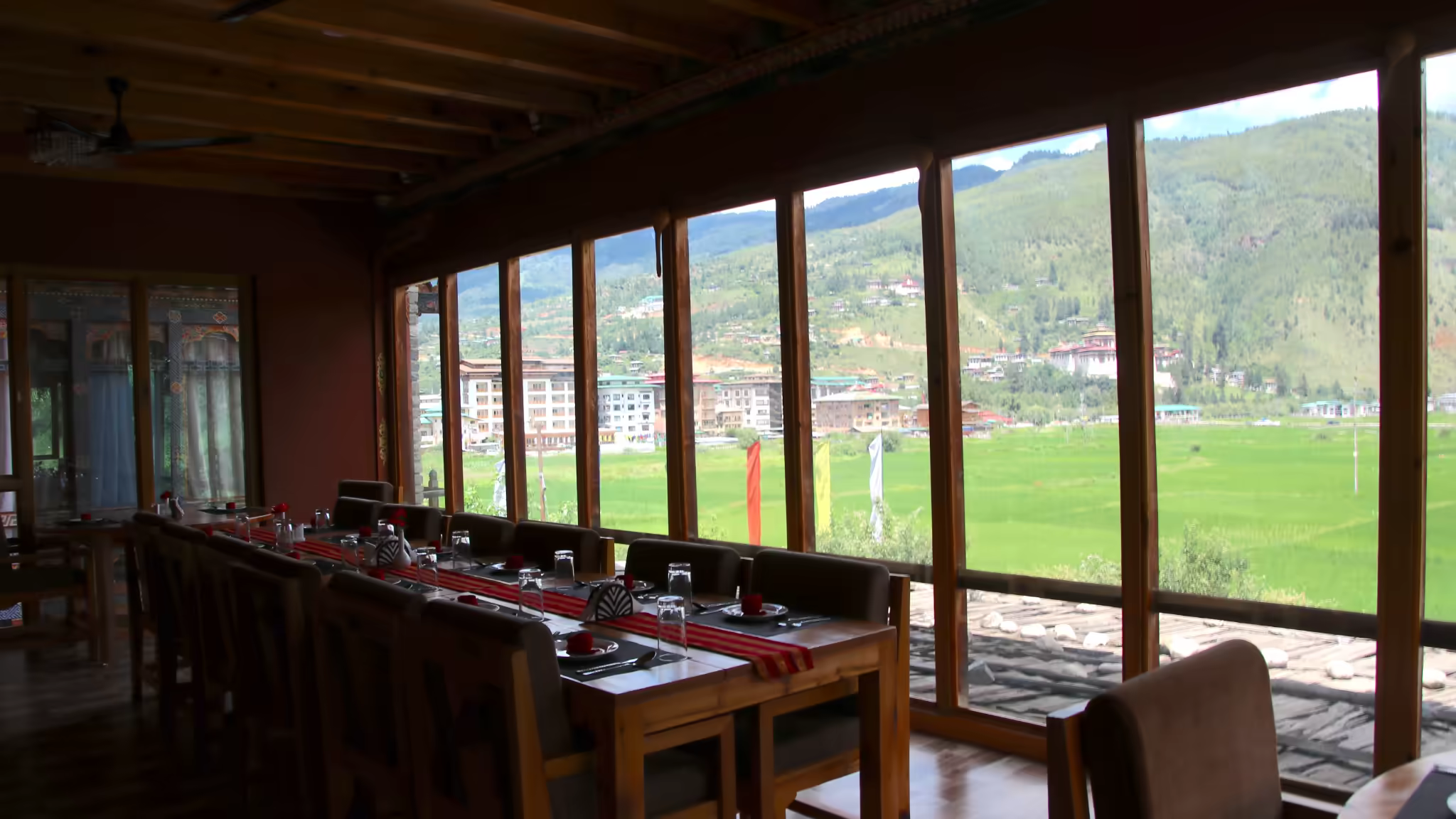 A Bhutanese-style dining room overlooking green fields and the Thimphu valley.