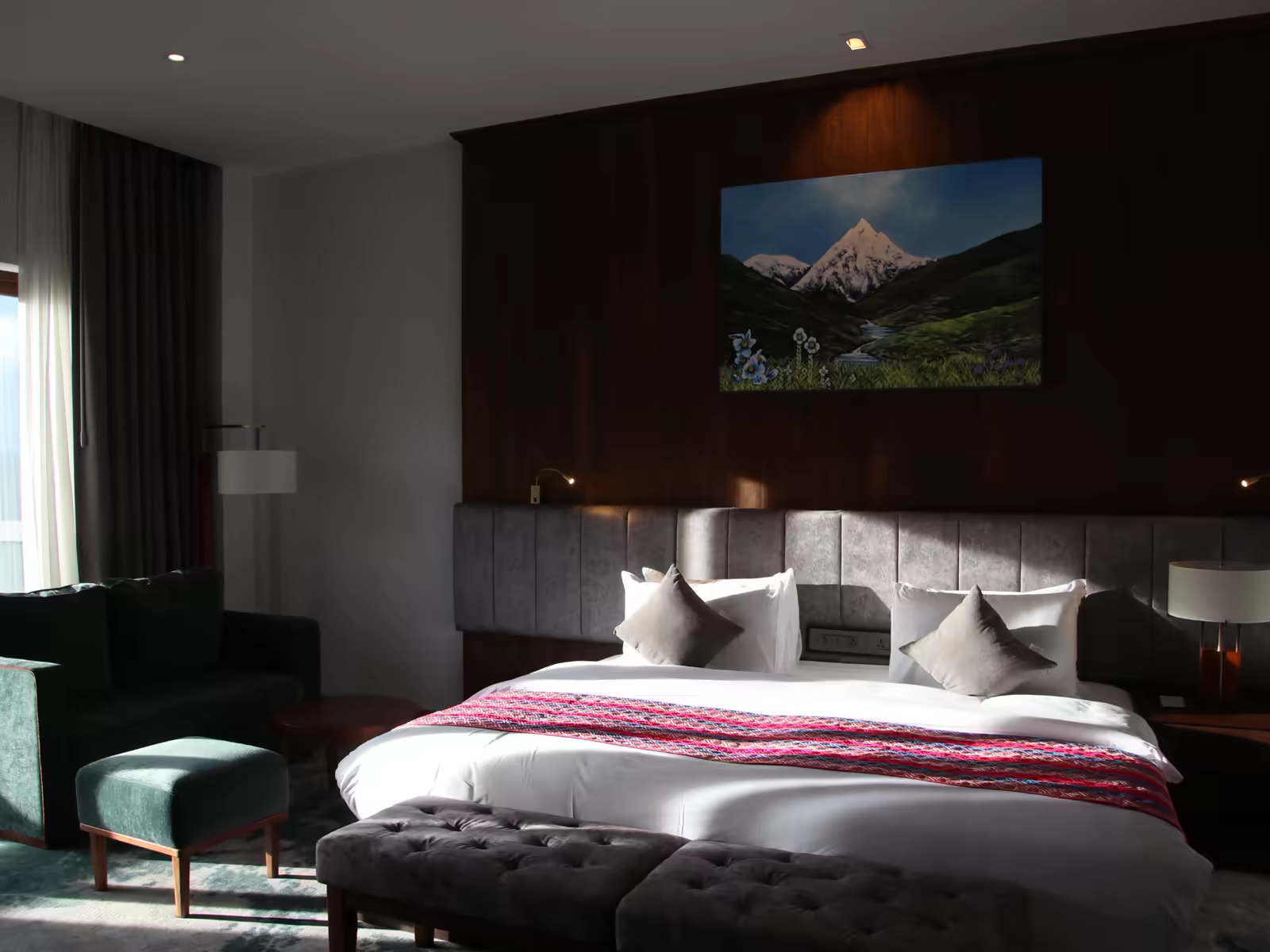 A warm Bhutan hotel room with timber finishes, local textiles and mountain artwork.