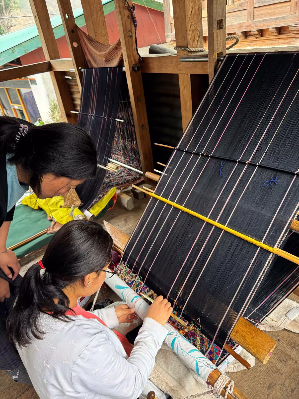 A Bhutanese weaver works at a traditional loom in eastern Bhutan.