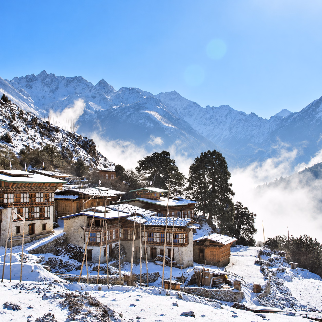 Snow-covered village houses in Laya beneath mountain ridges in Bhutan.
