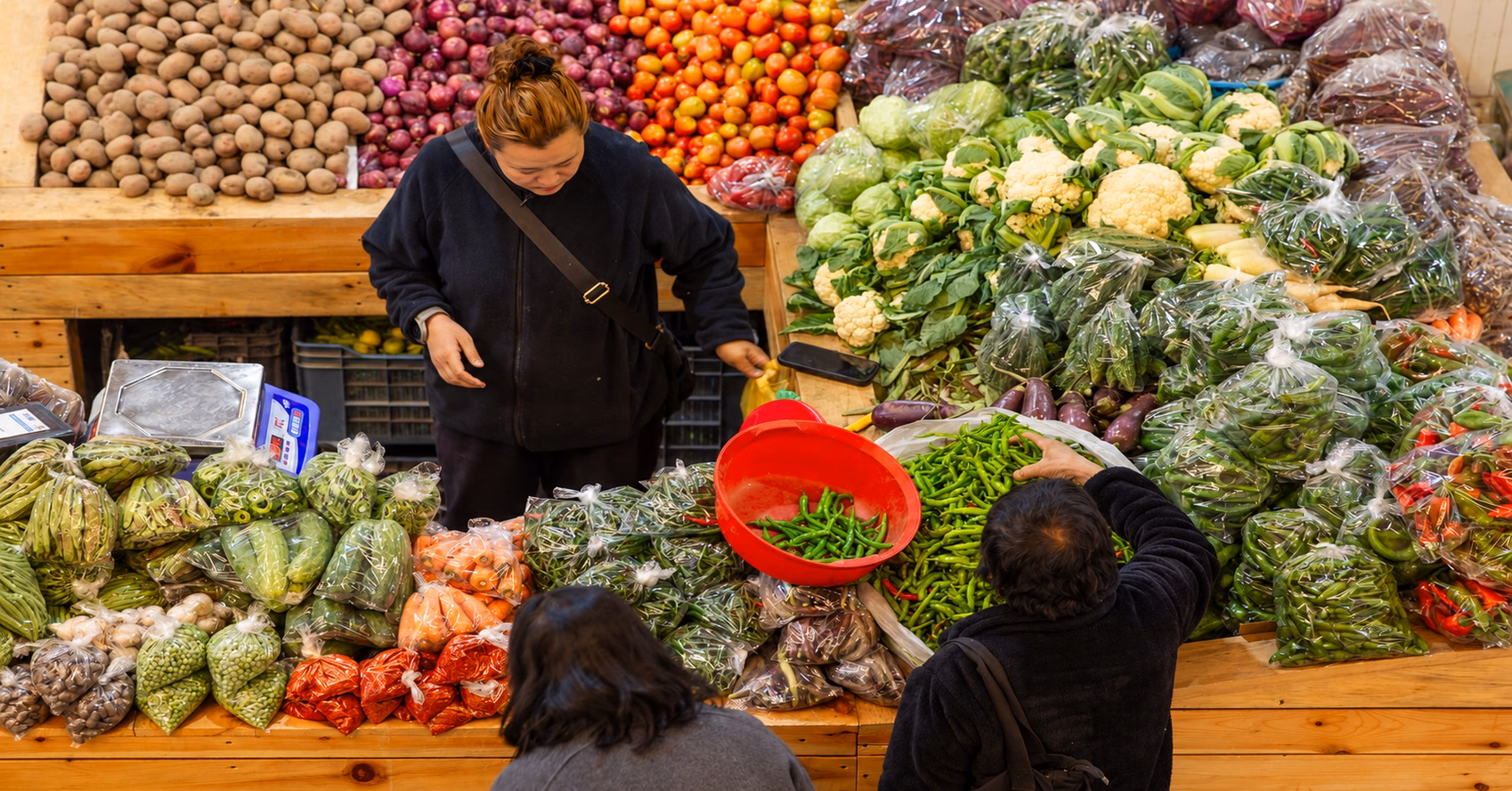 Vendor and shoppers among fresh vegetables at Thimphu’s farmers’ market