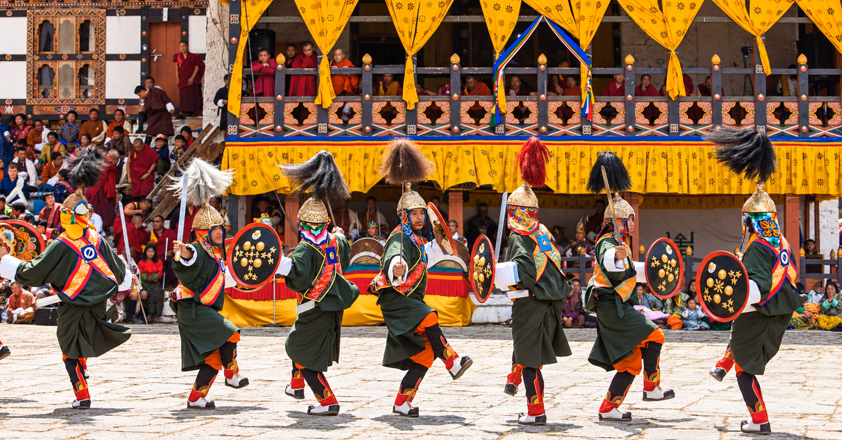 Ceremonial dancers carrying swords and shields at Punakha Dromchoe, Bhutan