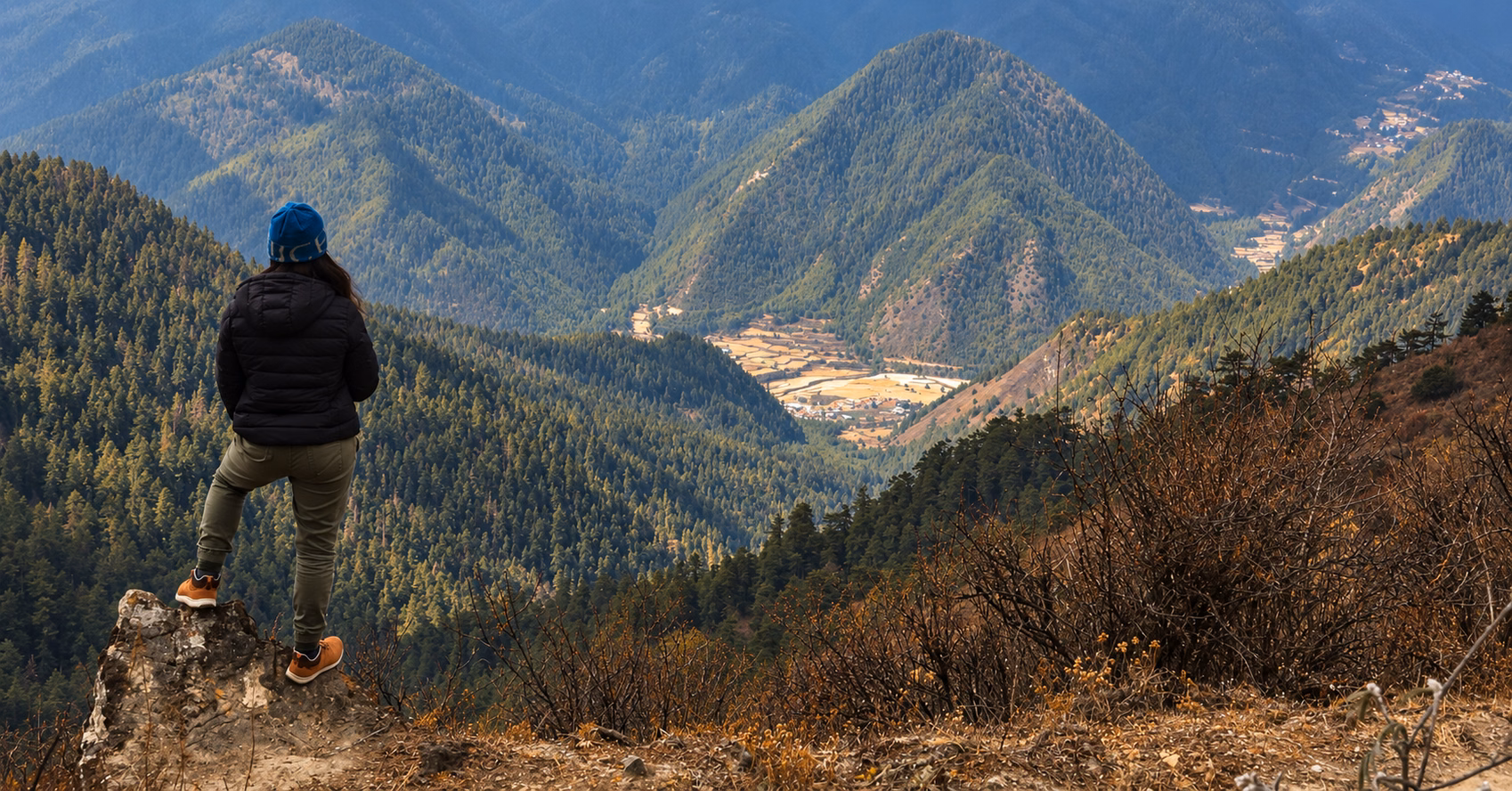 A traveller overlooking the forested mountains and valley near Haa, Bhutan