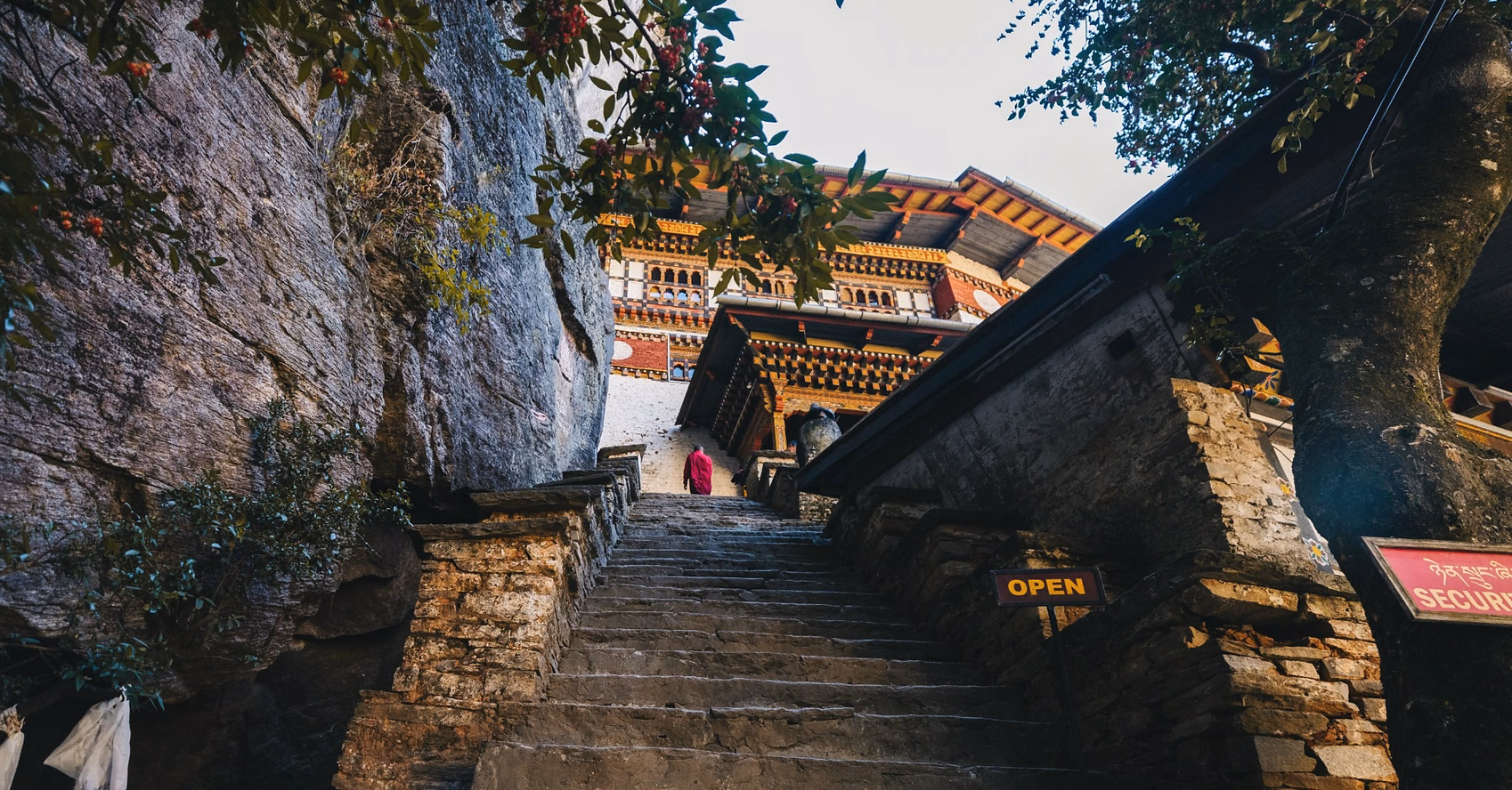 Stone steps leading to Tiger’s Nest Monastery in Paro, with a monk walking ahead